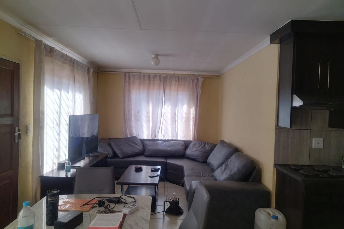 Open plan living and kitchen area featuring tiled flooring and direct access to the exterior.