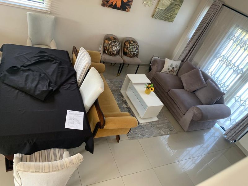 Open-plan living and dining area featuring polished tiled flooring and a sliding door with a security gate leading to the exterior.