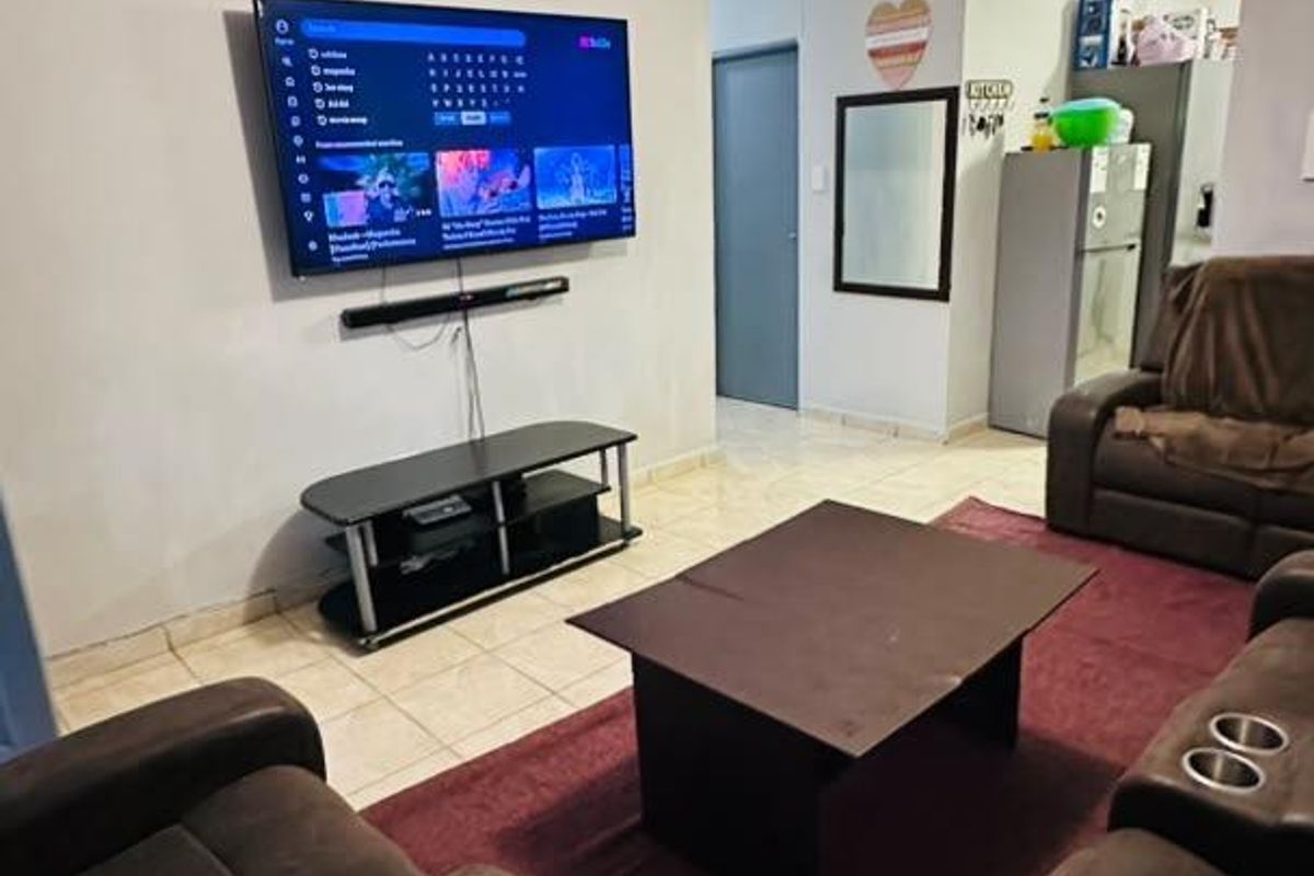 A functional living room featuring tiled flooring and coved ceilings, providing a comfortable space for relaxation and entertainment.