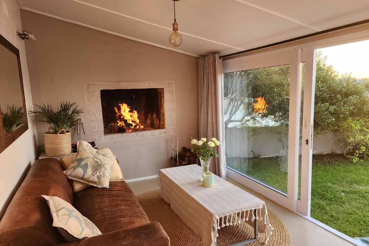 Cozy living room featuring a built-in fireplace and large sliding glass doors that provide seamless access to the garden.