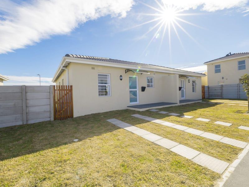 A well-maintained single-story residential property featuring a paved driveway, precast boundary walling, and modern exterior finishes under a clear sky.