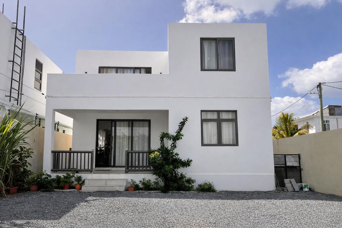A modern two-story residential property featuring a clean white facade, dark-framed windows, and a covered ground-floor patio area.