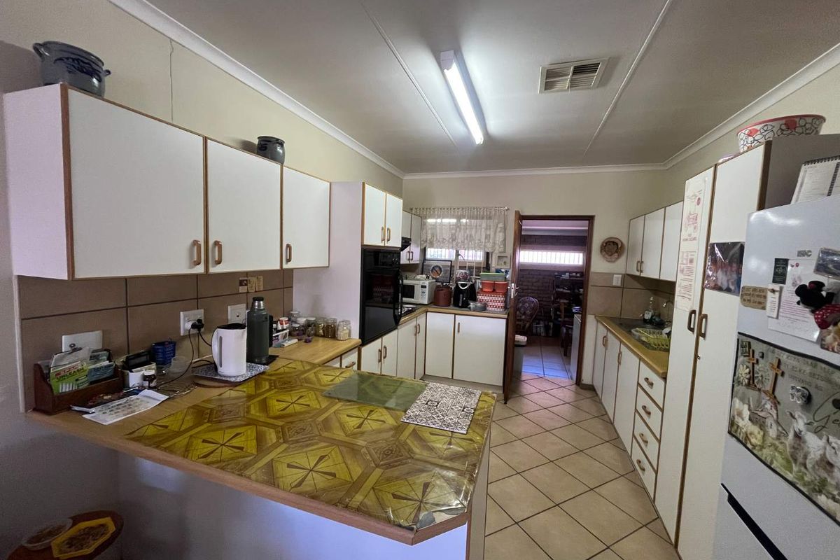 Functional kitchen featuring ample built-in cabinetry, laminate countertops, a built-in oven, and tiled flooring, offering a practical layout for daily meal preparation.