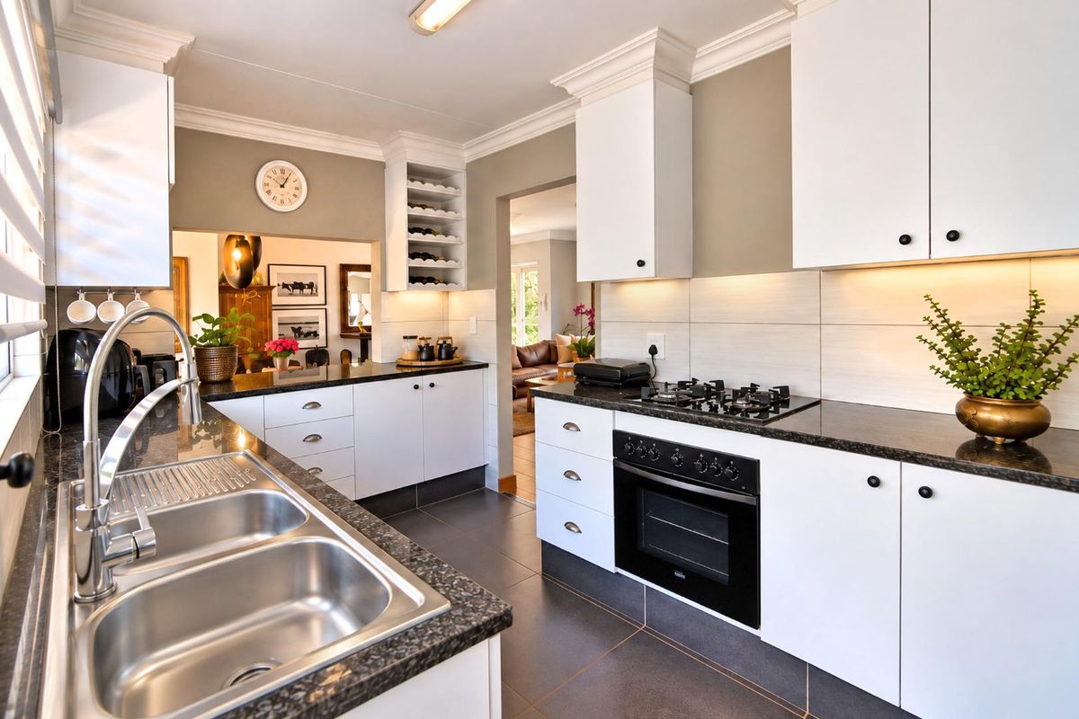 Modern kitchen featuring white cabinetry, granite countertops, built-in oven, gas cooktop, and a double bowl stainless steel sink with tiled backsplash.