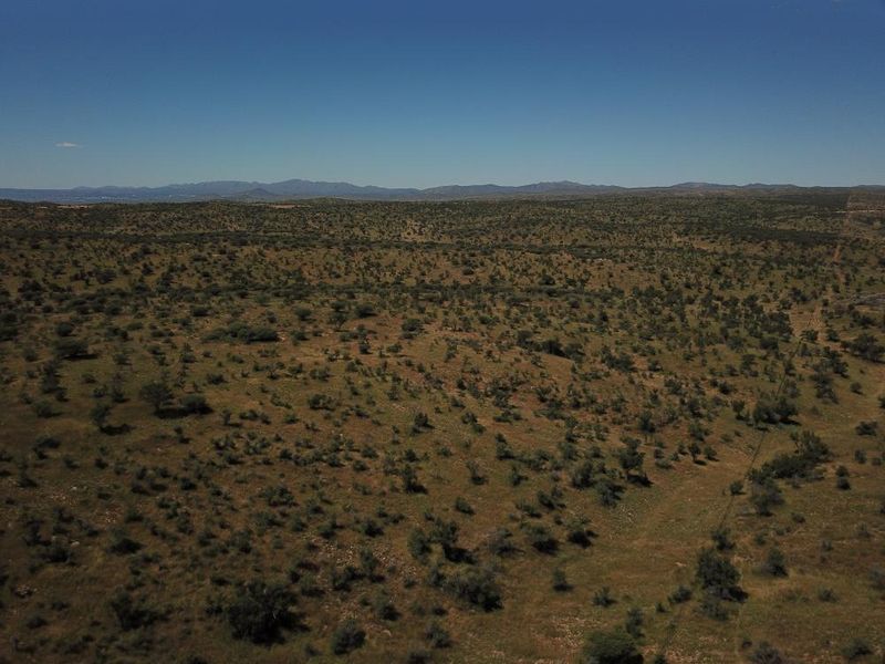 An expansive aerial view of the vacant residential land, showcasing the natural landscape and surrounding terrain.