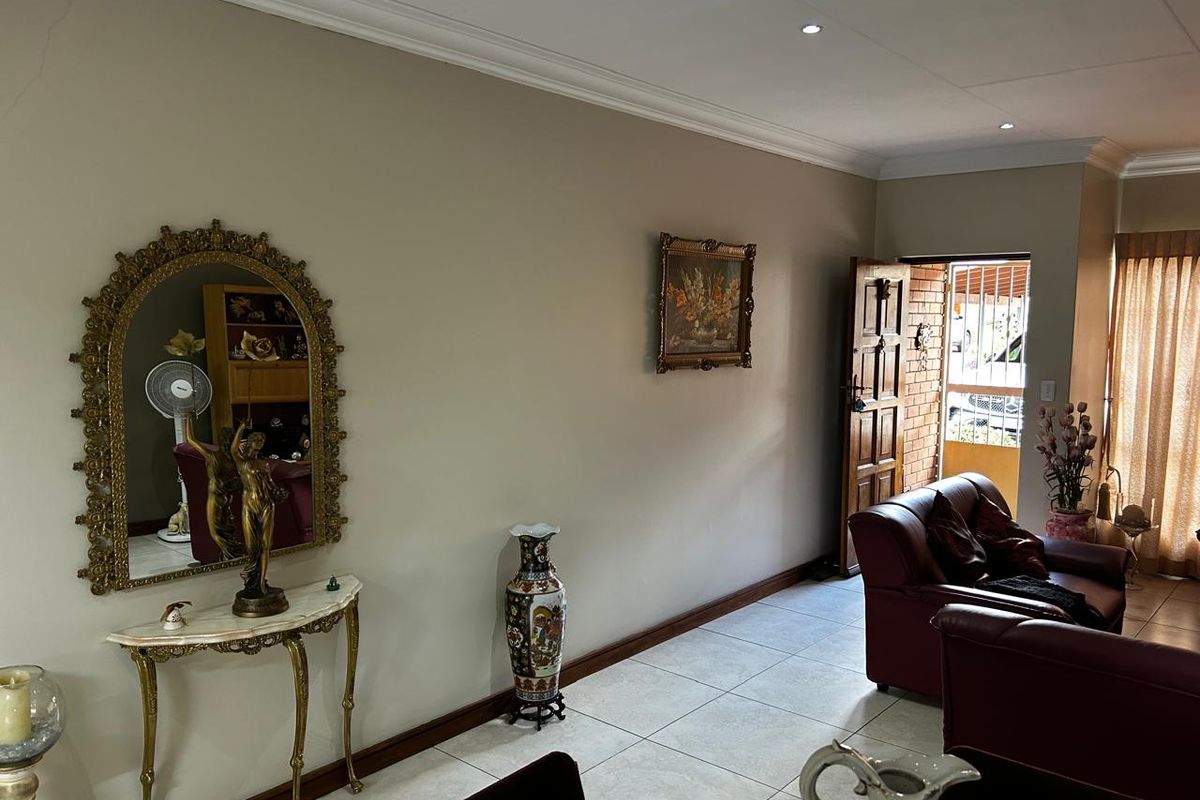 A view of the living area featuring tiled flooring, recessed ceiling lighting, and a solid timber entrance door with security gate.