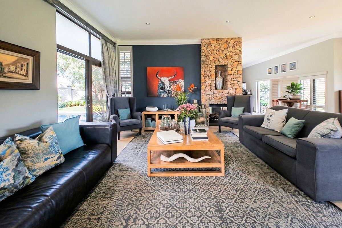 Spacious living room featuring a prominent stone-clad fireplace, large sliding glass doors providing natural light, and recessed ceiling lighting.