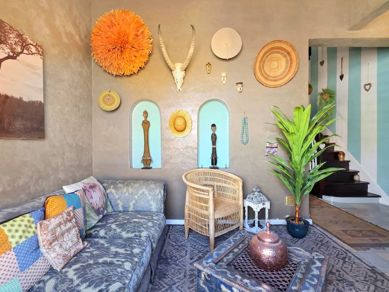 A living room featuring textured walls with built-in arched niches and a staircase leading to the upper level.