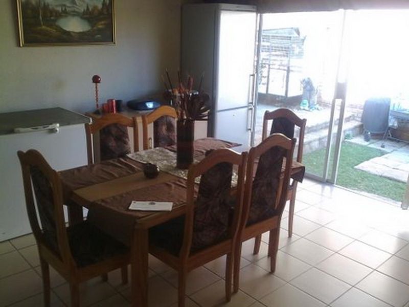 Dining area featuring tiled flooring and a sliding glass door providing direct access to the rear garden.