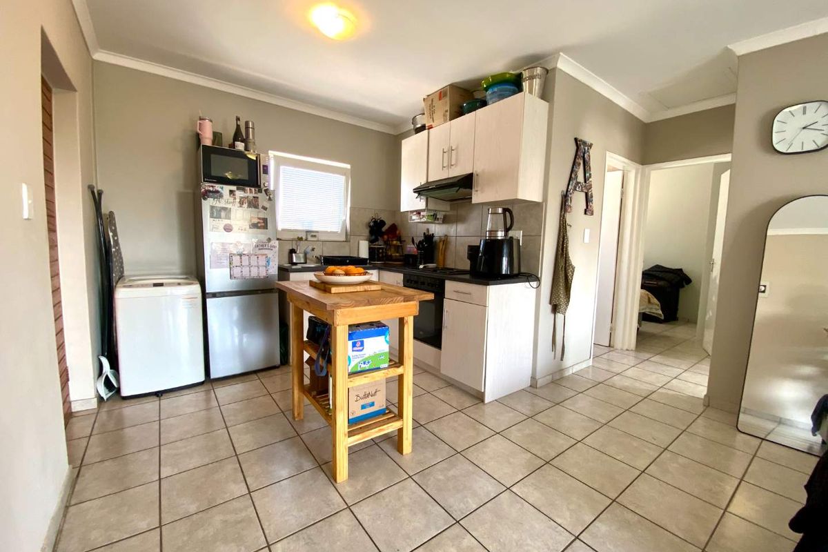 A functional kitchen featuring tiled flooring, built-in cabinetry, and integrated cooking appliances, offering a practical layout for daily meal preparation.