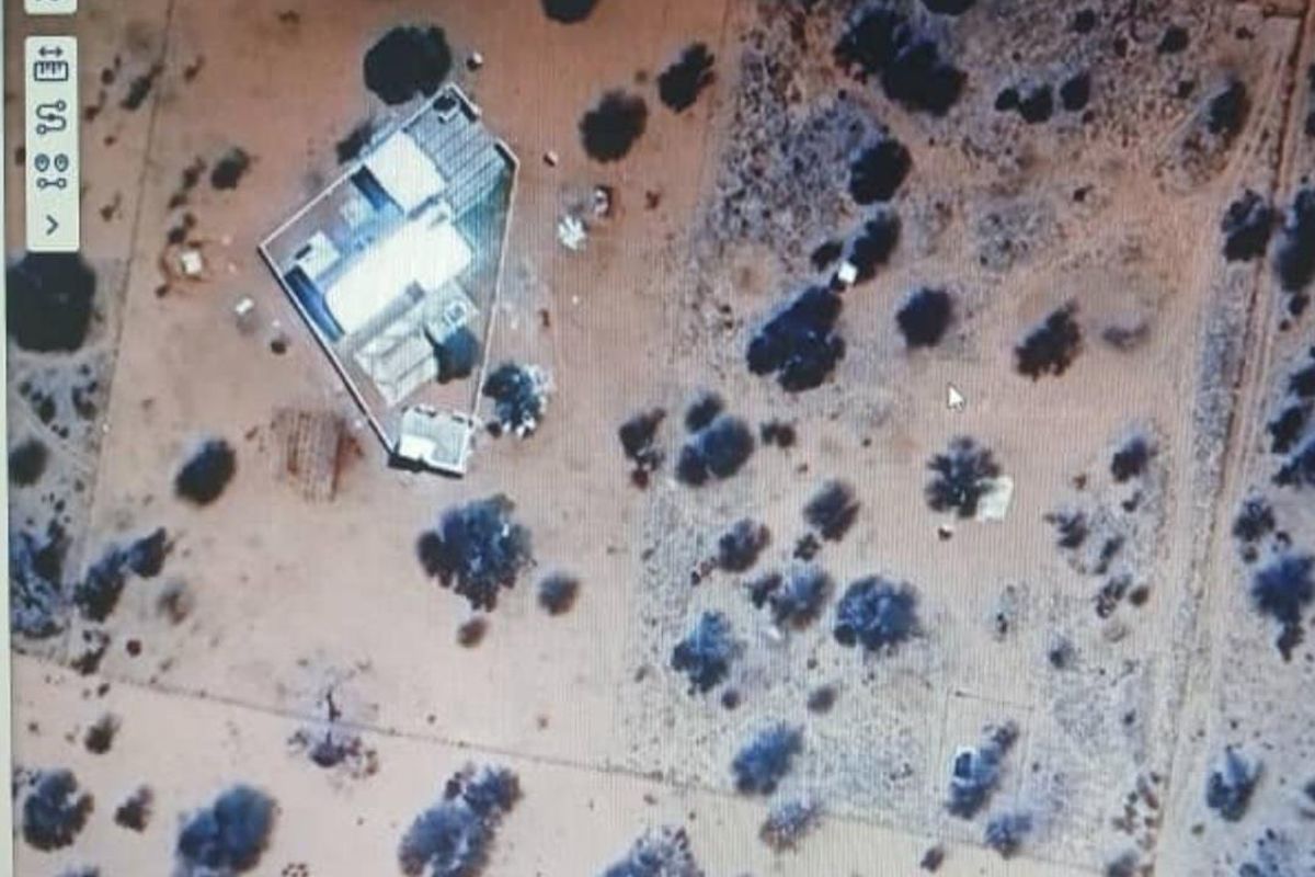 Aerial view of the small holding property showing the main dwelling structure and surrounding land with natural vegetation.