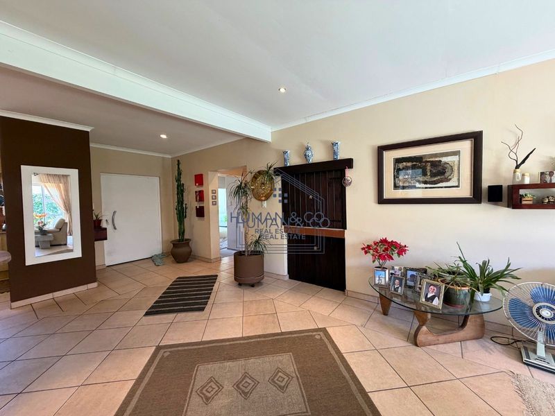 Spacious entrance hall featuring neutral wall tones and tiled flooring, providing a welcoming transition area into the main living spaces of the home.