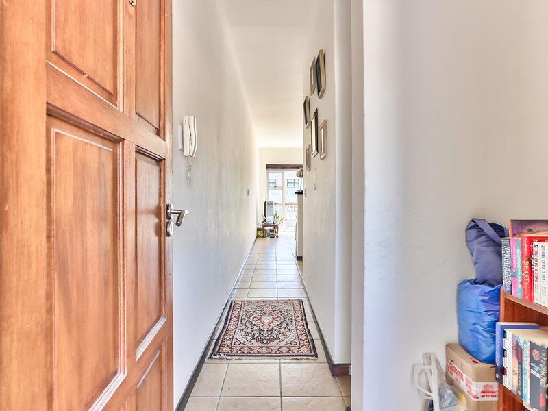 A functional hallway featuring tiled flooring and an intercom system, providing a clear transition between the entrance and the living area.