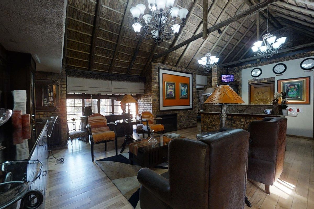Spacious reception area featuring a high vaulted thatched ceiling, exposed brick walls, and warm timber flooring, creating a rustic and welcoming atmosphere.