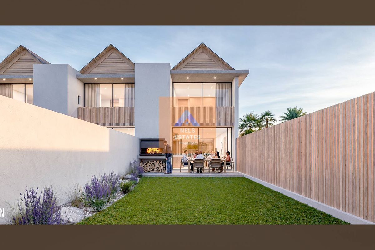 Rear exterior view of a modern townhouse featuring a private garden, paved patio area, and a built-in braai.