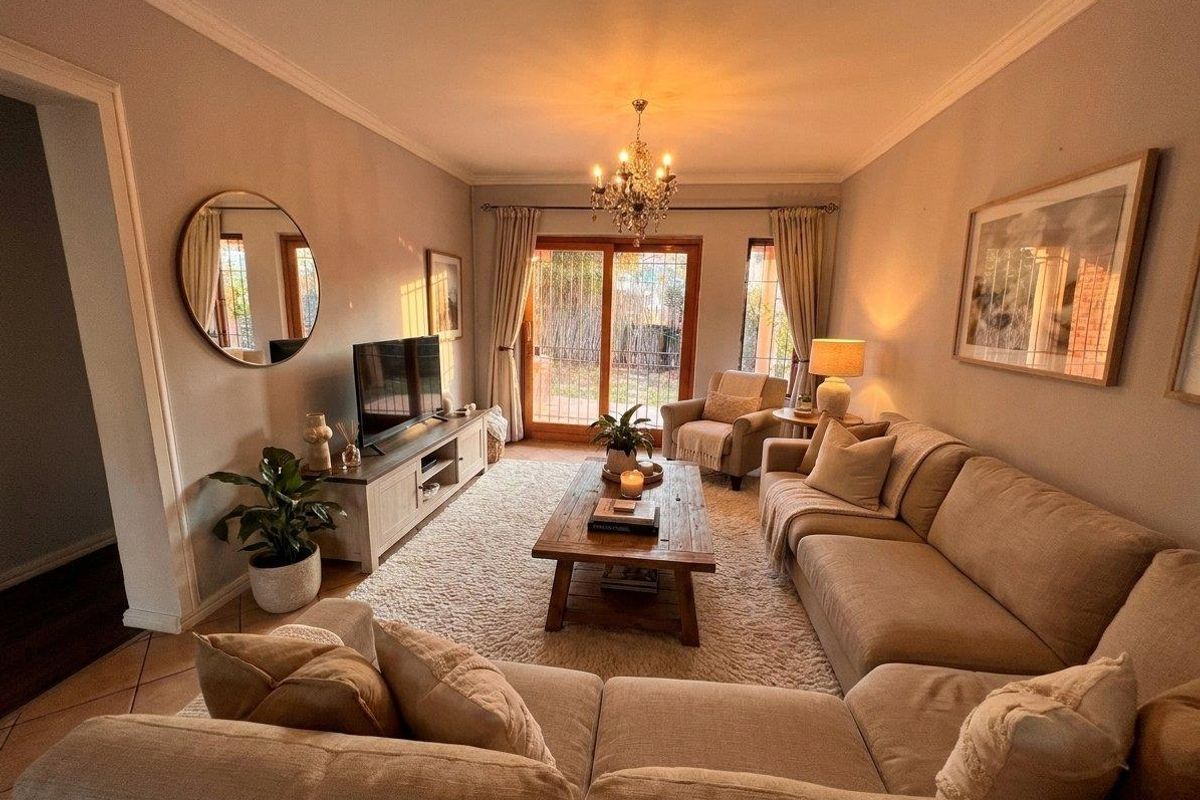 A cozy and well-maintained living room featuring crown molding, tiled flooring, and a sliding glass door that provides access to the outdoor area.