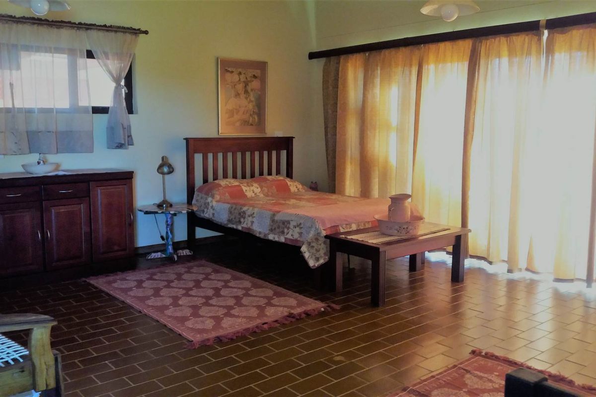 Spacious bedroom featuring tiled flooring and large sliding glass doors that provide ample natural light and access to the outdoors.