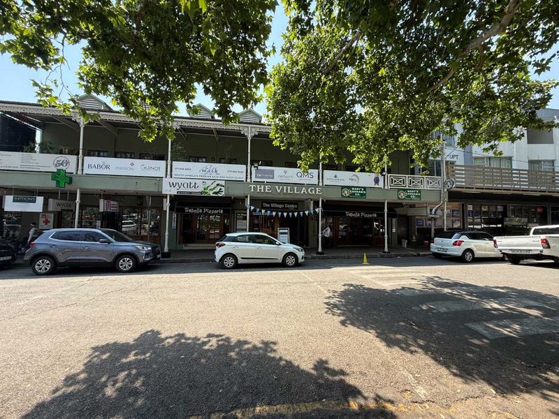 Street-level view of The Village retail centre, featuring a multi-tenant facade with traditional veranda architecture and established storefront signage.