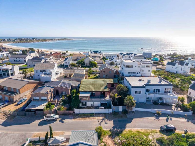 Aerial view of a coastal residential neighborhood showcasing proximity to the beach and surrounding property layout.