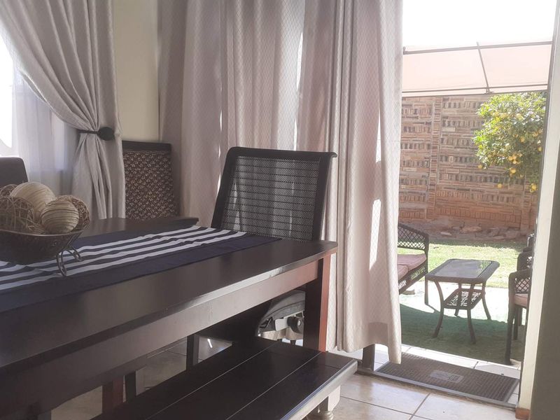 Dining area featuring tiled flooring and a sliding glass door providing direct access to the outdoor patio and garden space.