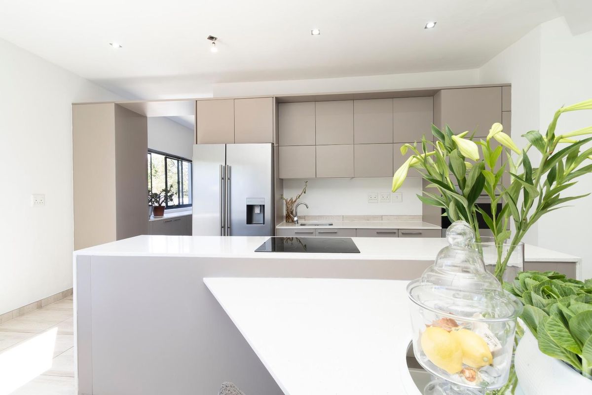 Modern kitchen featuring sleek cabinetry, a central island with an integrated cooktop, and high-quality finishes throughout.