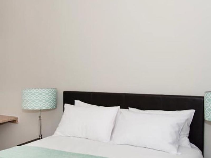 A well-maintained bedroom featuring neutral wall tones and classic coving detail, providing a clean and comfortable sleeping space.