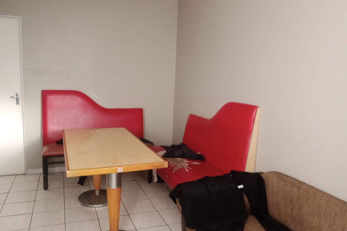 A simple interior space featuring tiled flooring and a plain wall finish, suitable for a casual dining or seating area.