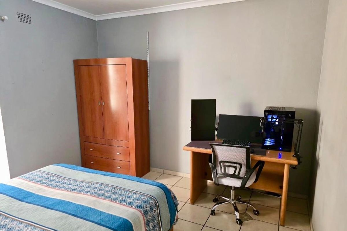 A functional bedroom featuring tiled flooring and neutral wall finishes, providing a versatile space for rest or study.