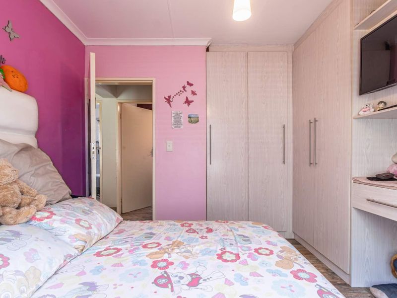 A bedroom featuring built-in cupboards, laminate flooring, and coving, providing functional storage and a neutral base for interior updates.