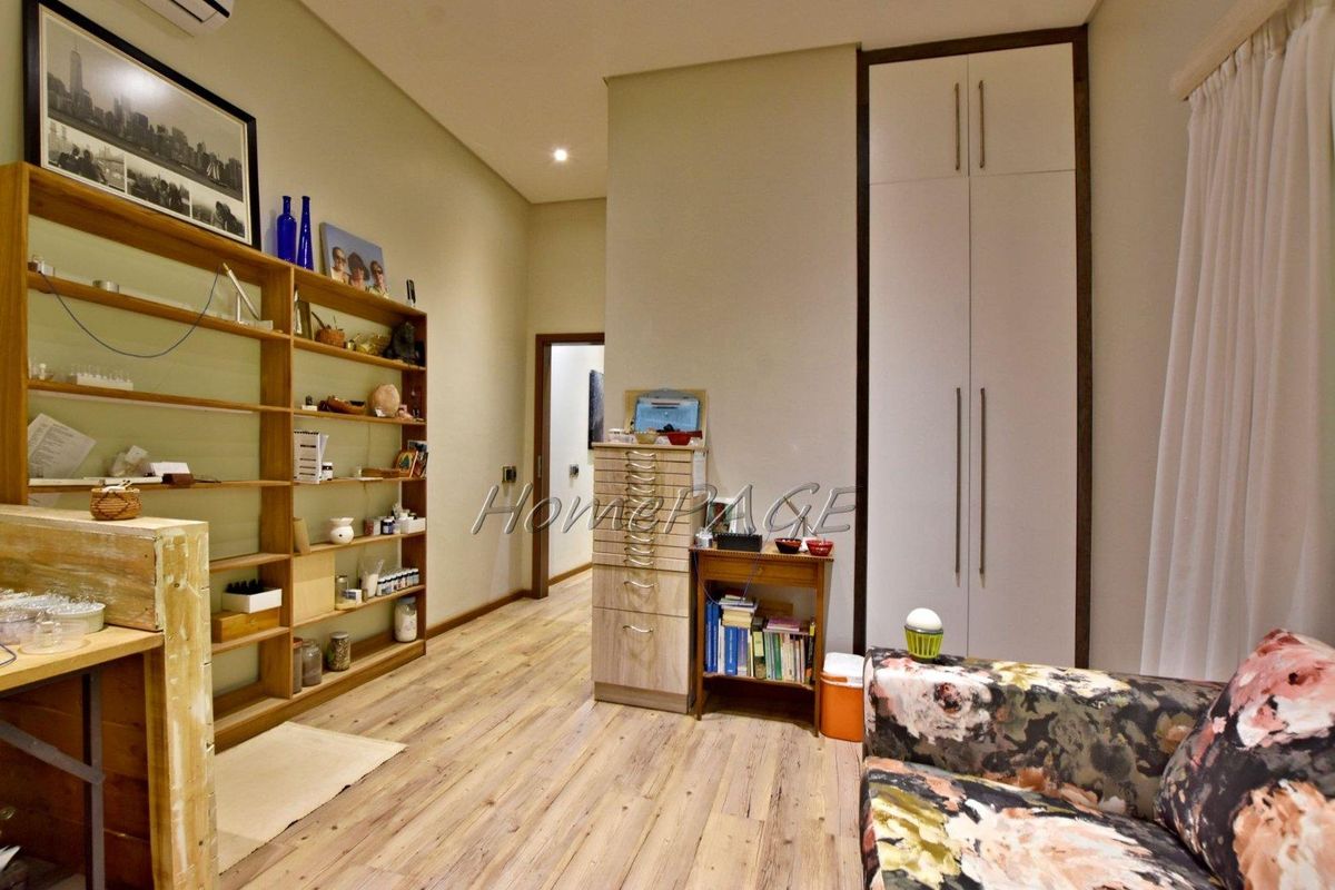 A bedroom featuring light wood-look flooring, built-in floor-to-ceiling cabinetry, and integrated shelving units.