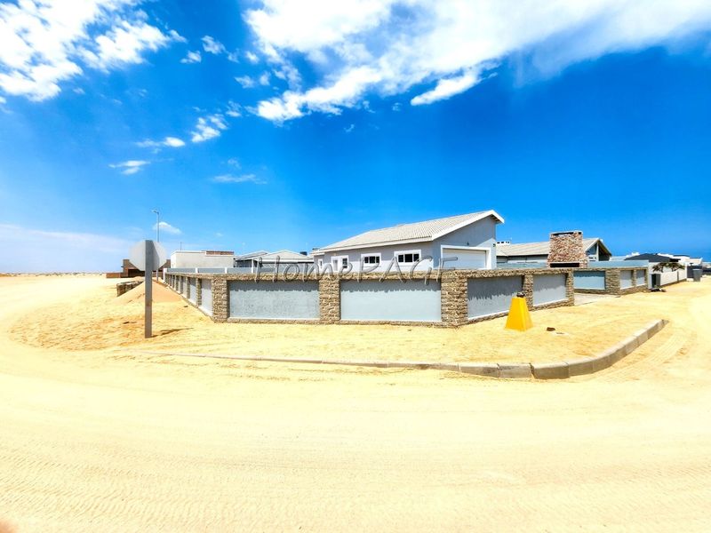 A view of the property exterior featuring a perimeter wall with stone masonry pillars, a tiled roof, and an external chimney.