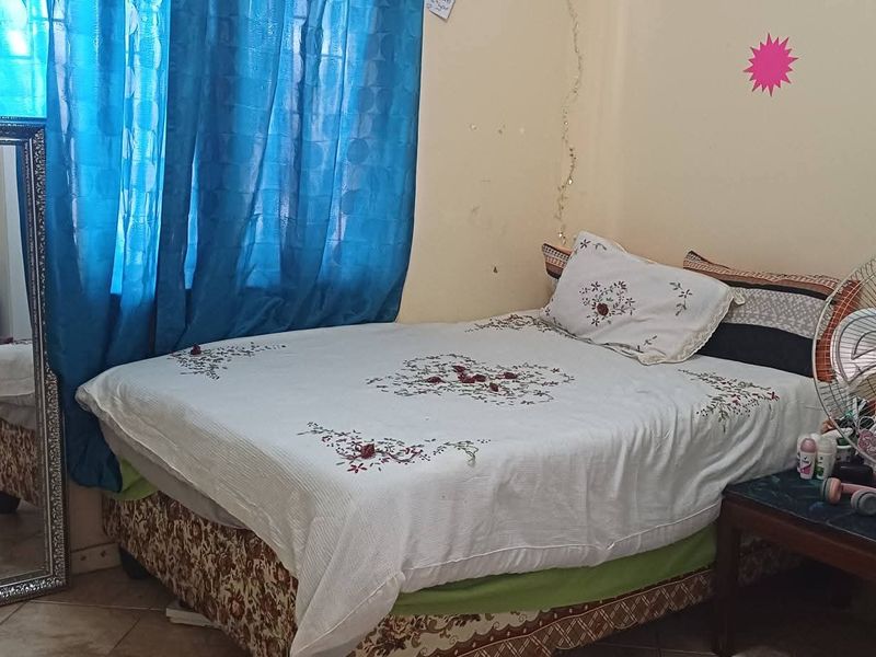 A bedroom featuring tiled flooring and neutral wall finishes, offering a functional space ready for cosmetic updates and personalization.