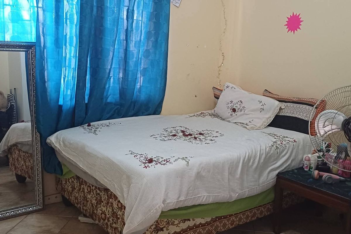 A bedroom featuring tiled flooring and neutral wall finishes, offering a functional space ready for cosmetic updates and personalization.