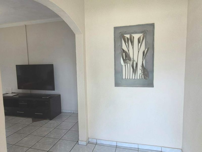 An entrance foyer featuring tiled flooring and an arched transition leading into the living area.