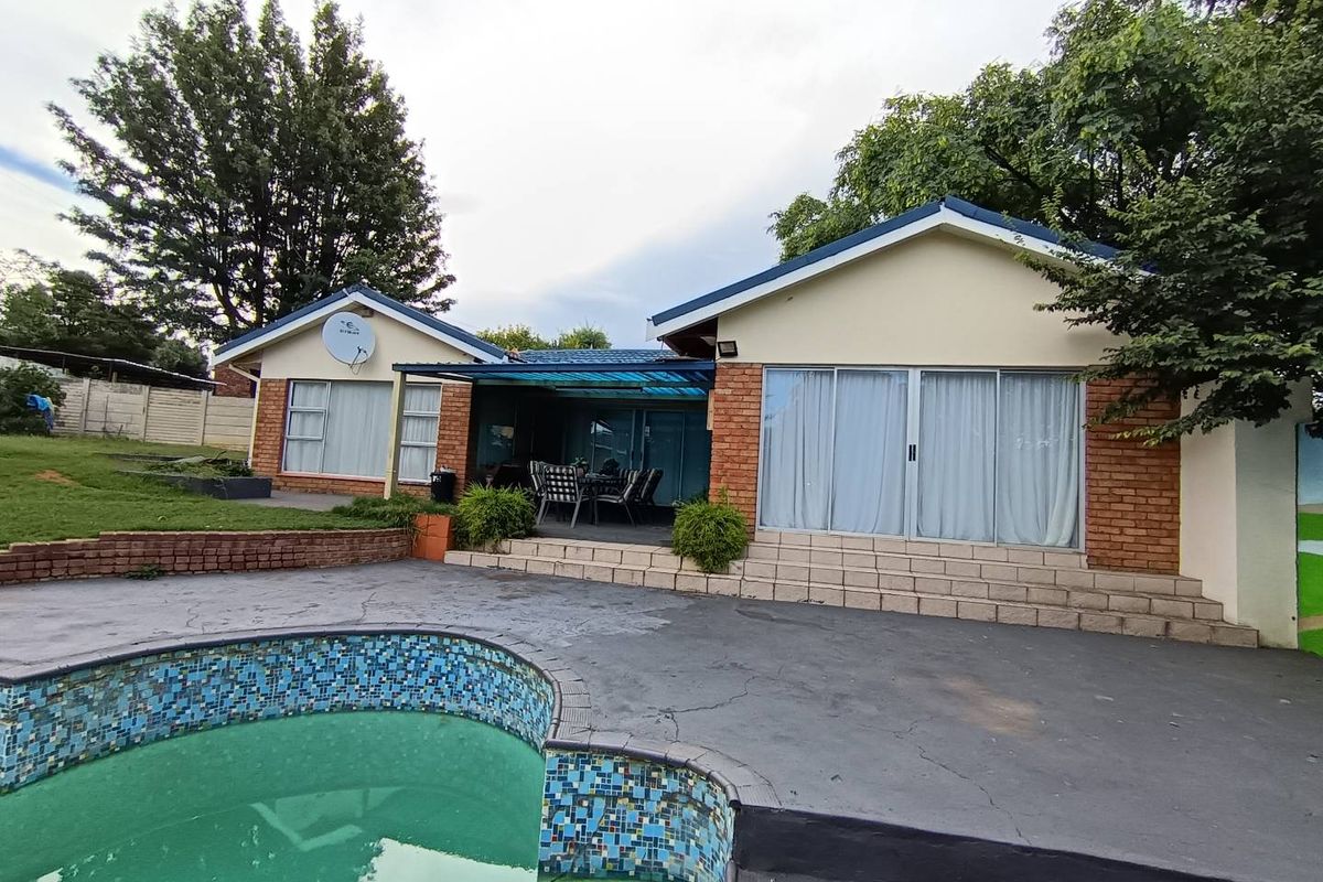 Rear view of the property featuring a swimming pool, paved patio area, and direct access to the home through sliding glass doors.