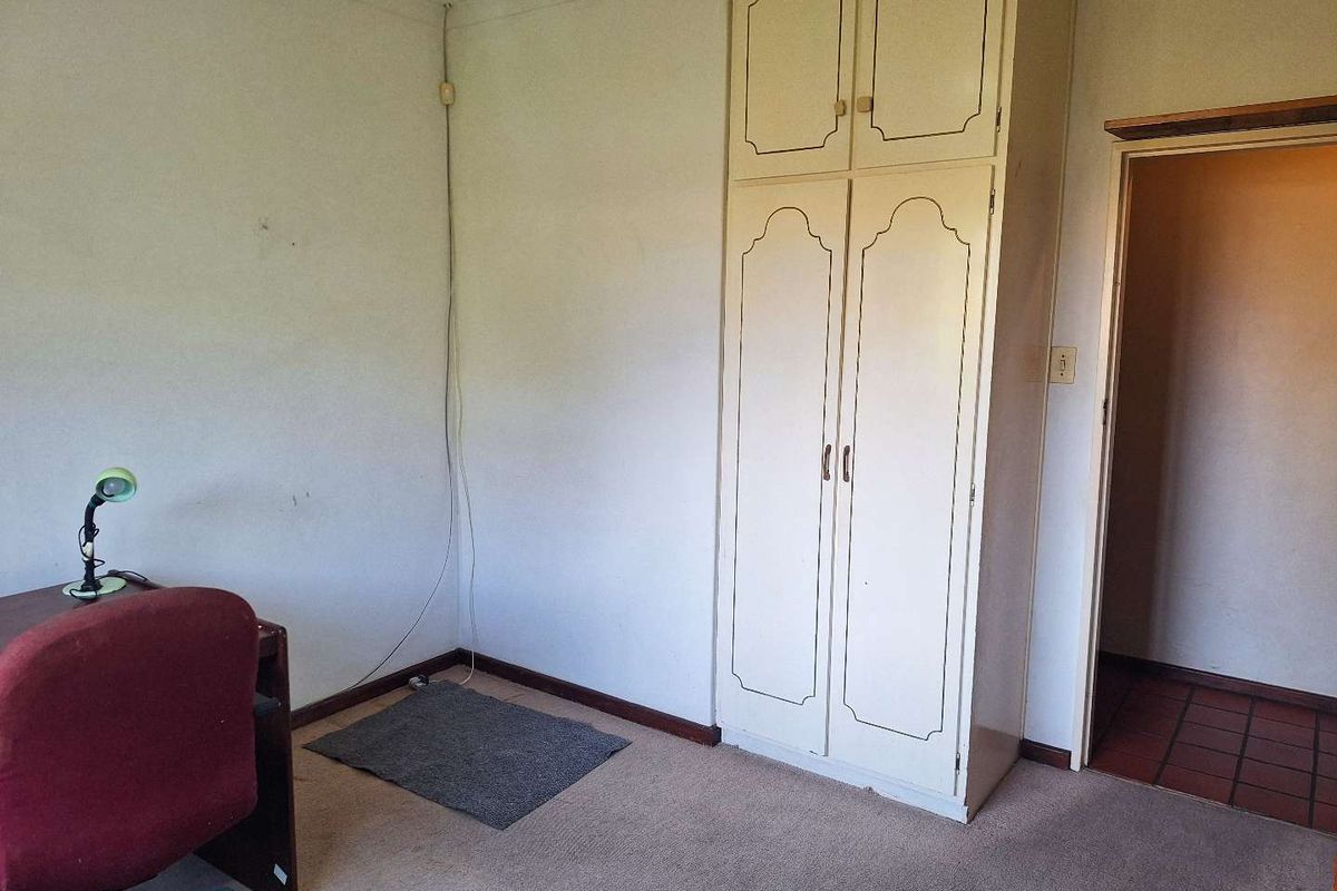 A bedroom featuring built-in cabinetry and carpeted flooring, requiring cosmetic updates to improve its overall condition and appeal.