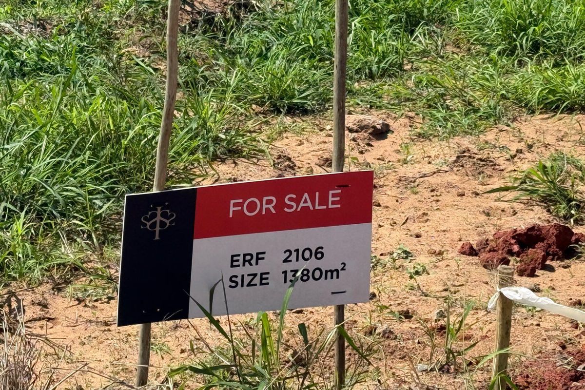 A vacant residential plot of land measuring 1380 square meters, currently marked with a for sale sign.