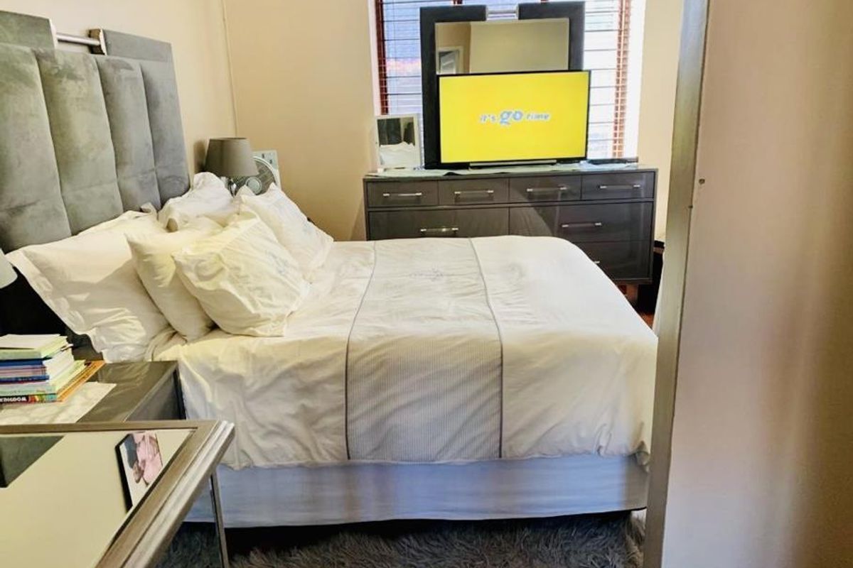 A well-lit bedroom featuring a large window with fitted blinds, providing a comfortable and functional sleeping space.