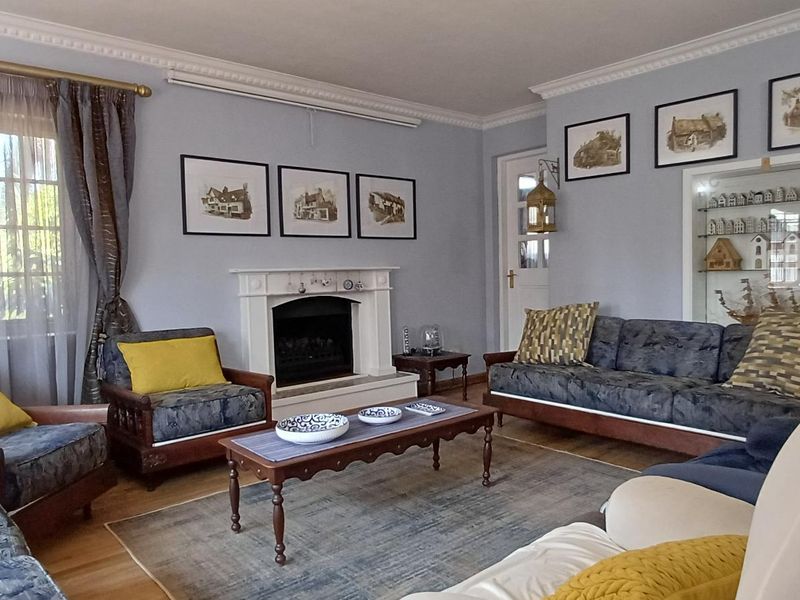 A comfortable living room featuring a classic fireplace with a mantelpiece, crown molding, and a built-in display cabinet, finished with hardwood flooring.
