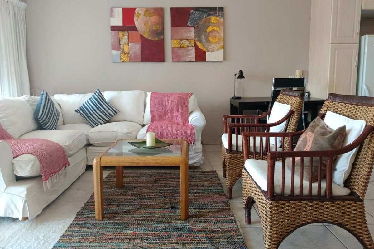 A comfortable living room featuring tiled flooring and neutral wall tones, providing a functional and inviting space for relaxation.