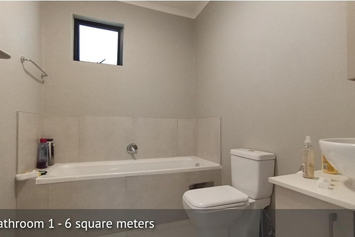 A functional bathroom featuring a built-in bathtub, a modern toilet, and a vanity with a vessel sink.