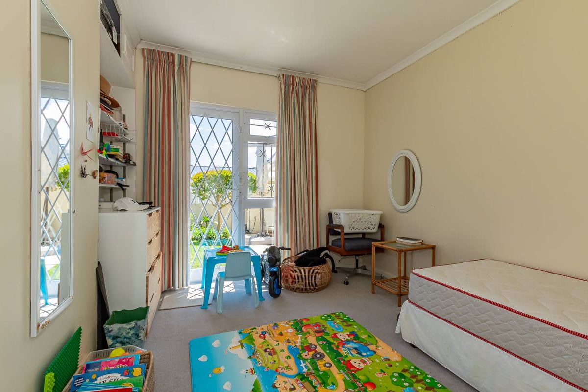 A bedroom featuring carpeted flooring, built-in shelving, and a glass security door providing direct access to the outdoor area.