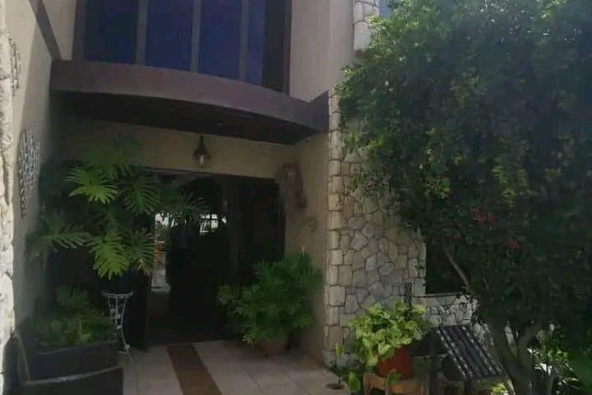 A modern front entrance featuring stone cladding accents, tiled walkway, and large windows, providing a welcoming and structured approach to the home.