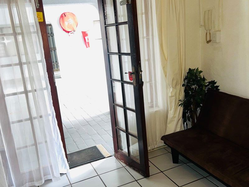 Entrance area featuring tiled flooring and a timber-framed glass door leading to an outdoor patio space.