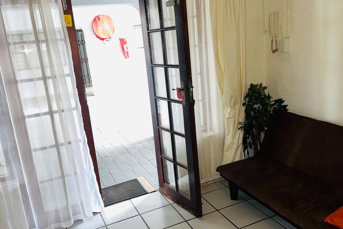 Entrance area featuring tiled flooring and a timber-framed glass door leading to an outdoor patio space.