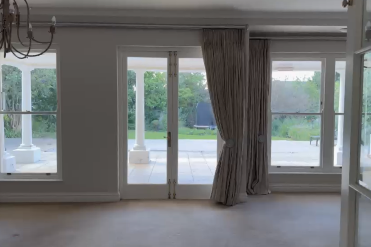 Spacious living room featuring classic sash windows, elegant french doors opening to a patio, and traditional cornice detailing.
