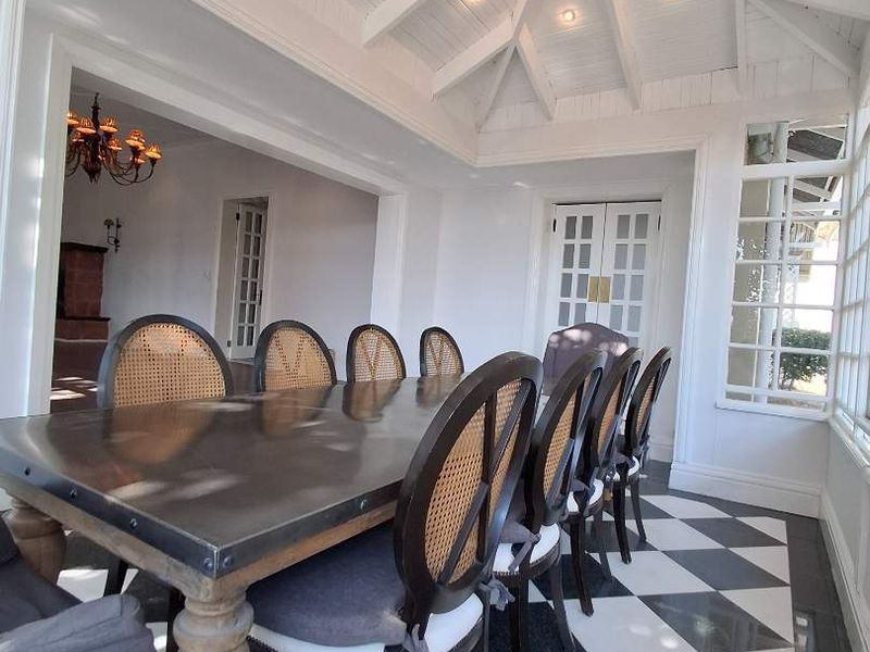 Bright dining room featuring a vaulted ceiling with exposed beams, skylight, recessed lighting, and elegant checkered marble flooring with access through french doors.
