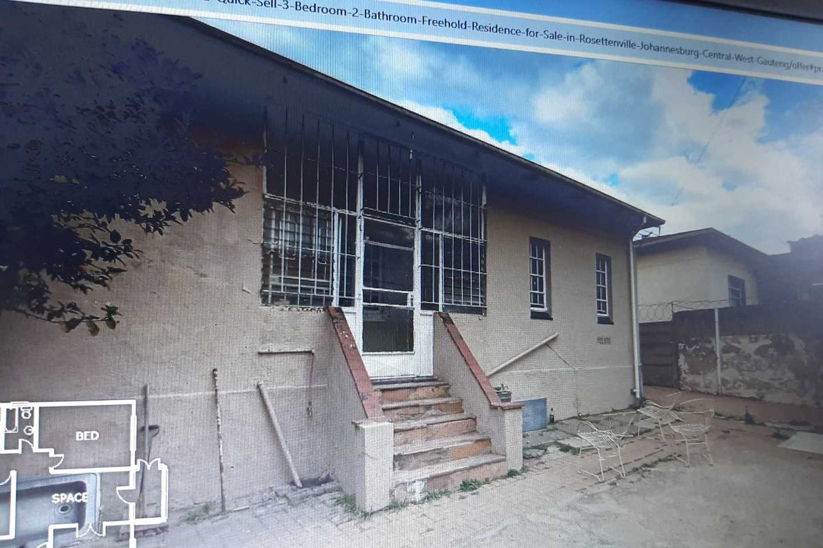Exterior view of the house featuring a concrete staircase leading to a security-gated entrance with metal burglar bars on windows.