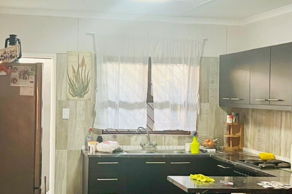 A functional kitchen featuring dark cabinetry, tiled backsplash, and a compact breakfast bar area, providing essential storage and workspace.