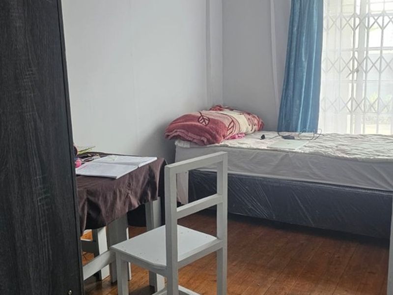 A bedroom featuring original hardwood flooring and decorative ceiling cornicing, providing a classic foundation for potential interior updates.